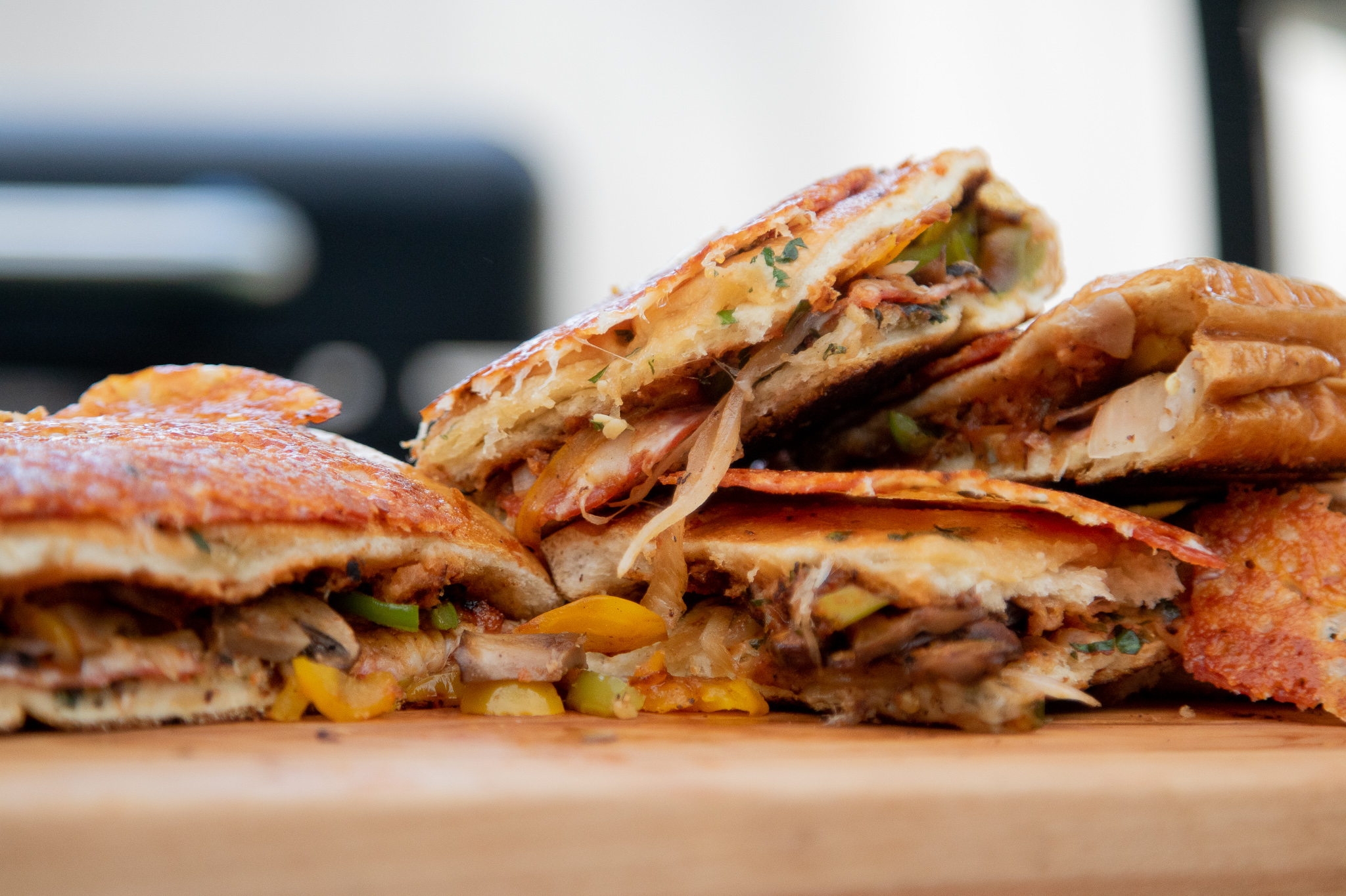 Gooey pizza sandwich cut in half on wood board