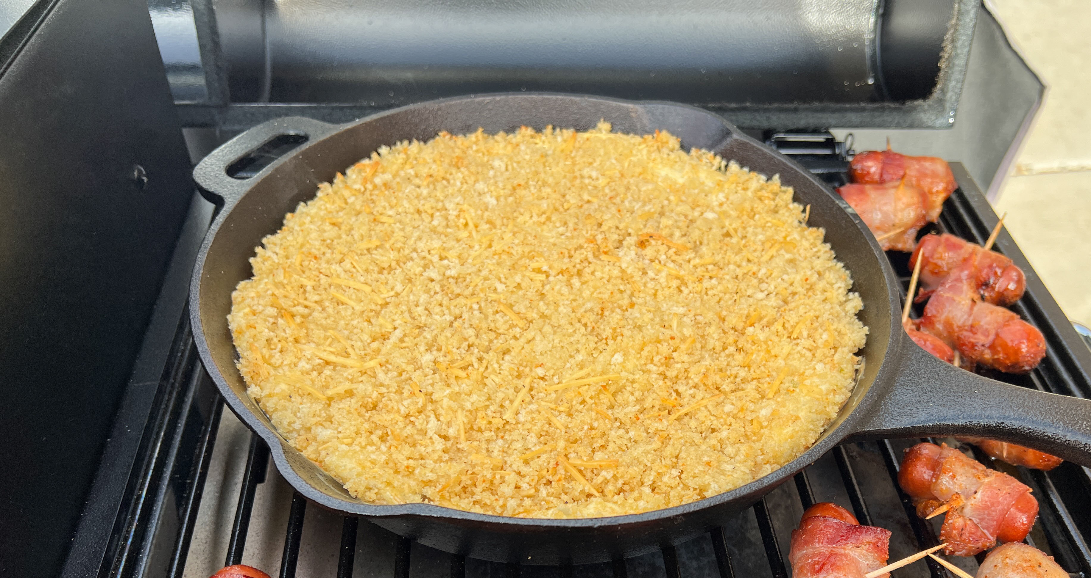 cheesy smoky appetizer dip smoked on a pellet grill in a cast iron skillet